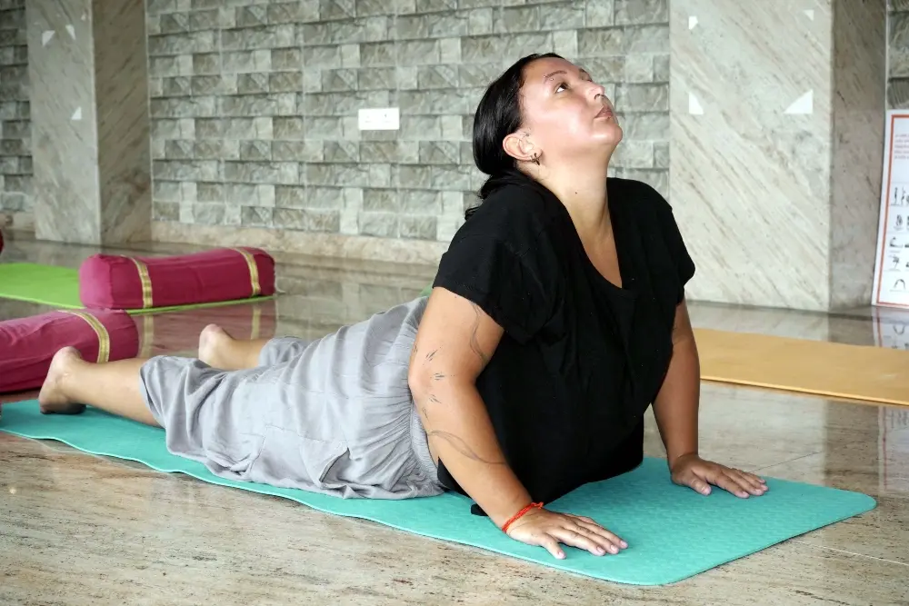 student practicing bhujangasana during hatha yoga training in rishikesh