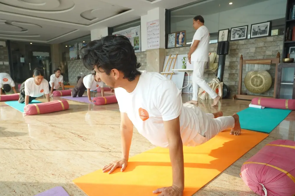 yoga teacher explaining bhujangasana in a hatha yoga class in rishikesh