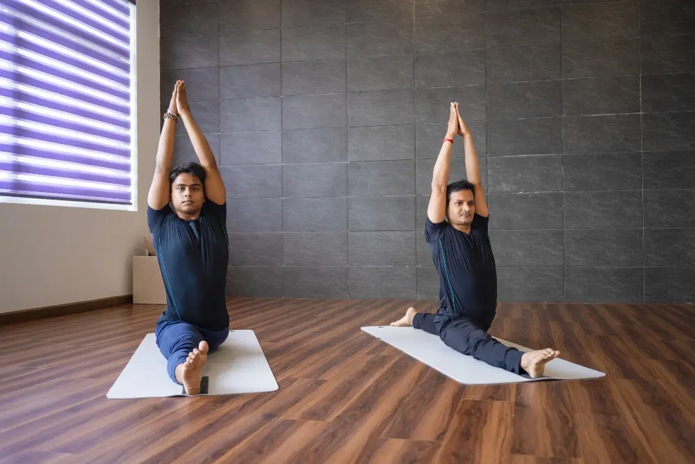 yoga students practising hanumanasana during a traditional yoga session in rishikesh
