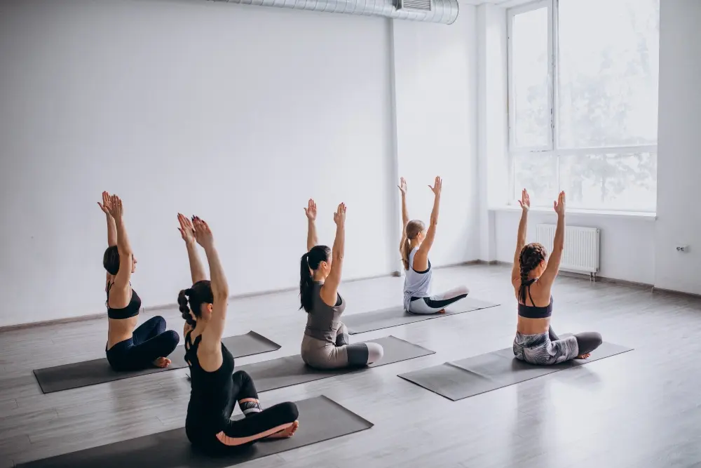 yoga students practicing seated stretching poses during a group yoga class at mrityunjay yogpeeth yoga students practicing seated stretching poses during a group yoga class at mrityunjay yogpeeth