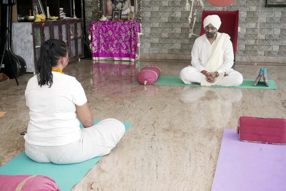 yoga teacher guiding a student through meditation practice at mrityunjay yogpeeth yoga teacher guiding a student through meditation practice at mrityunjay yogpeeth