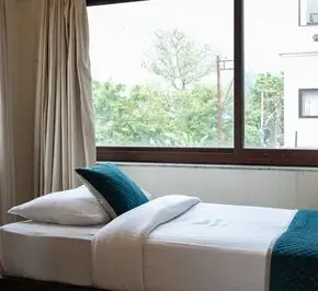 Comfortable single room with natural light for spiritual healing yoga retreat guests